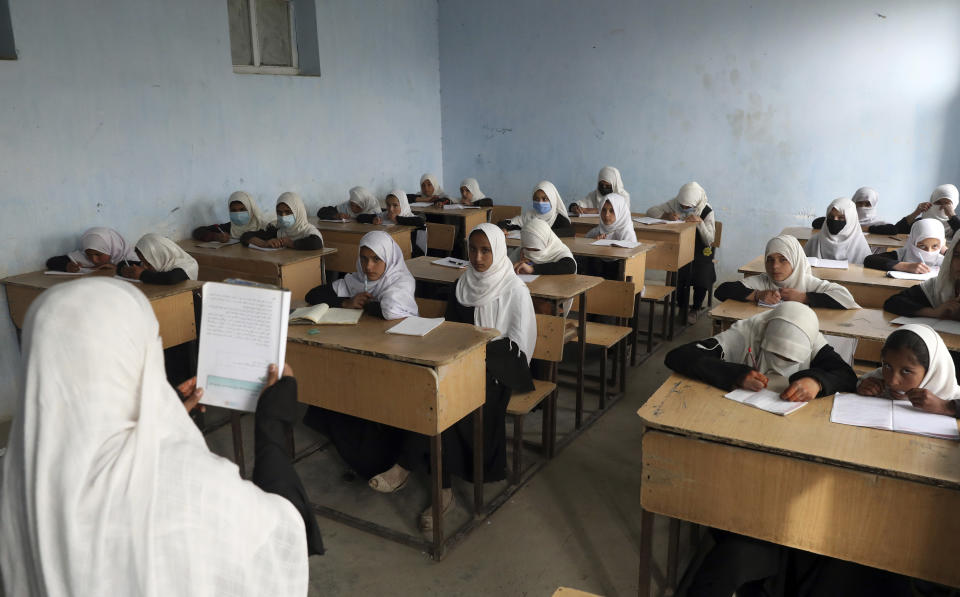 FILE- Afghan girls students attend school classes in a primary school in Kabul, Afghanistan, Saturday, March 27, 2021. Afghan girls will be allowed to take their high school graduation exams this week, an official and documents from the Taliban government indicated Tuesday, Dec. 6, 2022 even though they have been banned from classrooms since the former insurgents took over the country last year. (AP Photo/Rahmat Gul, File)