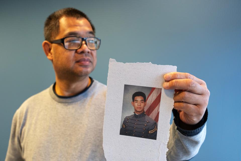 James Yee, a former U.S. Army captain and Muslim chaplain at Guantanamo Bay, holds up a photo of himself from West Point. He was jailed and held in solitary confinement for 76 days after being falsely accused of espionage. All charges were eventually dropped, and he received an honorable discharge.