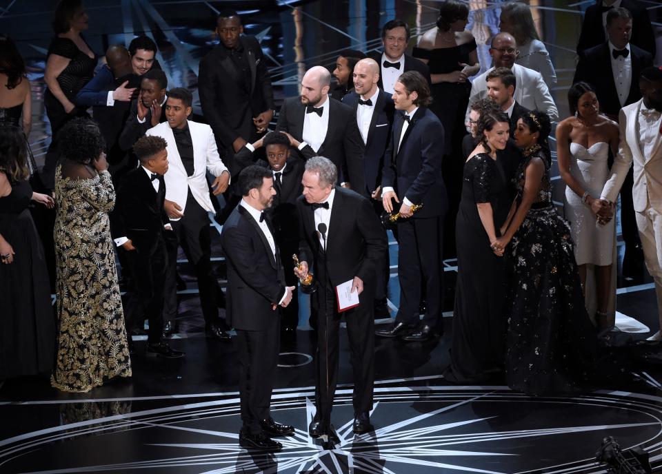 Host Jimmy Kimmel, left, and presenter Warren Beatty discuss the results of best picture as the casts of "La La Land" and "Moonlight," winner of best picture, react on stage at the Oscars on Sunday, Feb. 26, 2017, at the Dolby Theatre in Los Angeles. (Photo by Chris Pizzello/Invision/AP) ORG XMIT: CADA425
