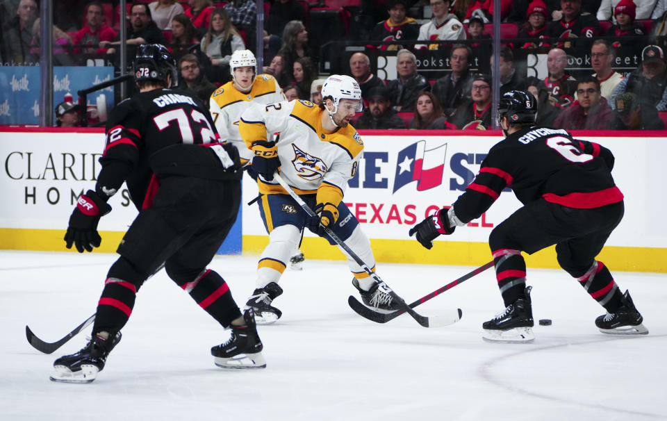 Nashville Predators center Tommy Novak (82) tries to skate the puck past Ottawa Senators defensemen Thomas Chabot (72) and Jakob Chychrun (6) during the first period of an NHL hockey game in Ottawa, Ontario, Monday, Jan. 29, 2024. (Sean Kilpatrick/The Canadian Press via AP)