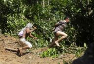 RNPS - REUTERS NEWS PICTURE SERVICE - PICTURES OF THE YEAR 2014 - ODDLY A Ka'apor Indian warrior (L) chases a logger who tried to escape after he was captured during a jungle expedition to search for and expel loggers from the Alto Turiacu Indian territory, near the Centro do Guilherme municipality in the northeast of Maranhao state in the Amazon basin, in this August 7, 2014 file photo. REUTERS/Lunae Parracho/Files (BRAZIL - Tags: ENVIRONMENT CIVIL UNREST POLITICS TPX IMAGES OF THE DAY)