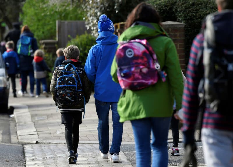 Parents walk their children to school in West London