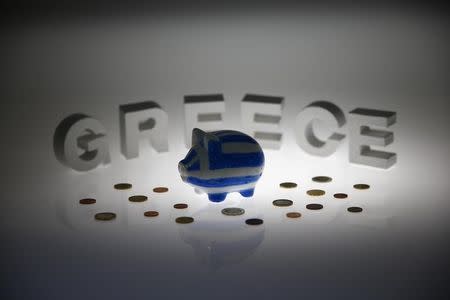 A piggybank painted in the colours of the Greek flag stands amongst various euro coins in front of letters spelling the word 'GREECE' in this picture illustration taken in Berlin, Germany June 30, 2015. REUTERS/Pawel Kopczynski