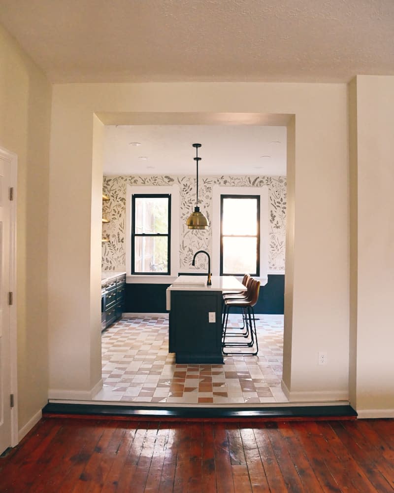 Neutral tiles in newly renovated kitchen with floral wallpaper.