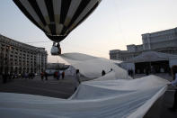 A Guinness World Record for the longest train of a wedding dress is attempted in front of the Parliament palace in Bucharest March 20, 2012. The 2,750 meter long train broke a previous record of 2,488 meters. It is made of 4,700 meters of material using 1,857 needles, taking 100 days to made. REUTERS/Bogdan Cristel