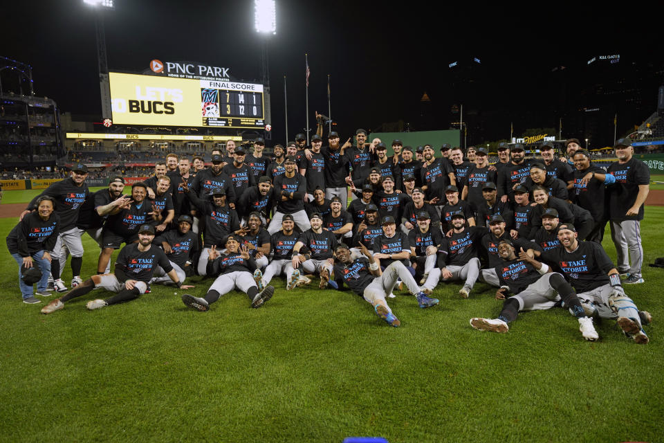 The Miami Marlins pose on the field at PNC Park in Pittsburgh after clinching a playoff berth with a win over the Pittsburgh Pirates in a baseball game Saturday, Sept. 30, 2023. (AP Photo/Gene J. Puskar)