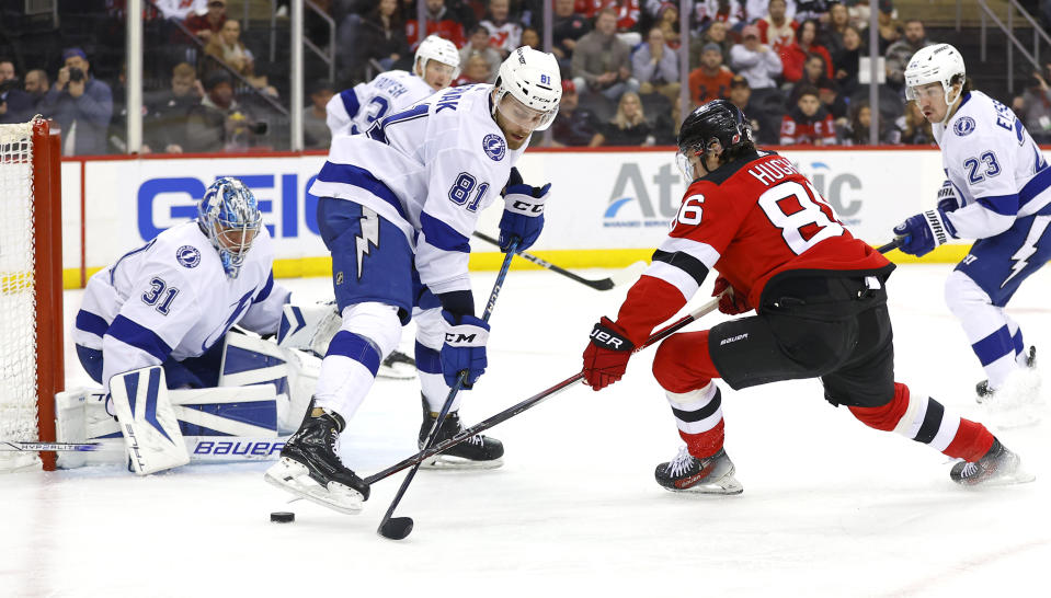 New Jersey Devils center Jack Hughes (86) plays the puck against Tampa Bay Lightning defenseman Erik Cernak (81) during the second period of an NHL hockey game, Sunday, Feb. 25, 2024, in Newark, N.J. (AP Photo/Noah K. Murray)