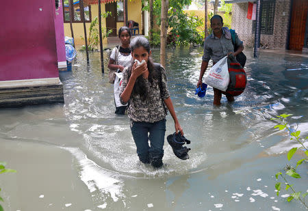 Residents carry their belongings as they evacuate their house after flooding caused by Cyclone Ockhi in the coastal village of Chellanam in the southern state of Kerala, India, December 2, 2017. REUTERS/Sivaram V