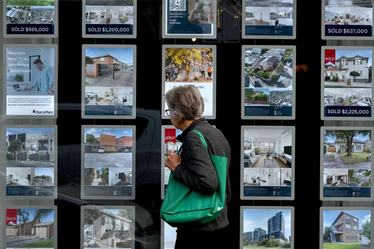 A woman inspects listings at a real estate agency. (Credit: William West, AFP via Getty Images) 