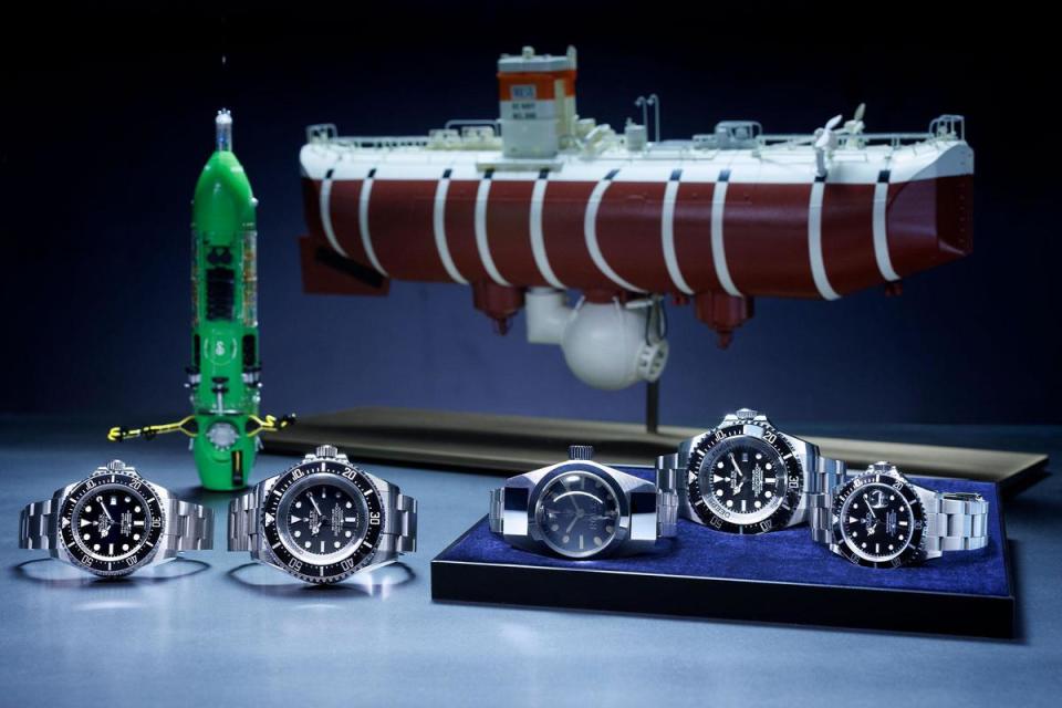 （由左至右）Oyster Perpetual Rolex Deepsea（2008）、Oyster Perpetual Deepsea Challenge（2022）、Deep Sea Special（1960）、Rolex Deepsea Challenge（2012）及Oyster Perpetual Submariner（1986）。後方由左至右：深海挑戰者號潛艇及深海潛艇的里雅斯特號的模型。 