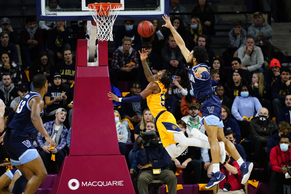 La Salle's Khalil Brantley, center, goes up for a shot past Villanova's Caleb Daniels, right, during the first half of an NCAA college basketball game, Sunday, Nov. 28, 2021, in Philadelphia. (AP Photo/Matt Slocum)