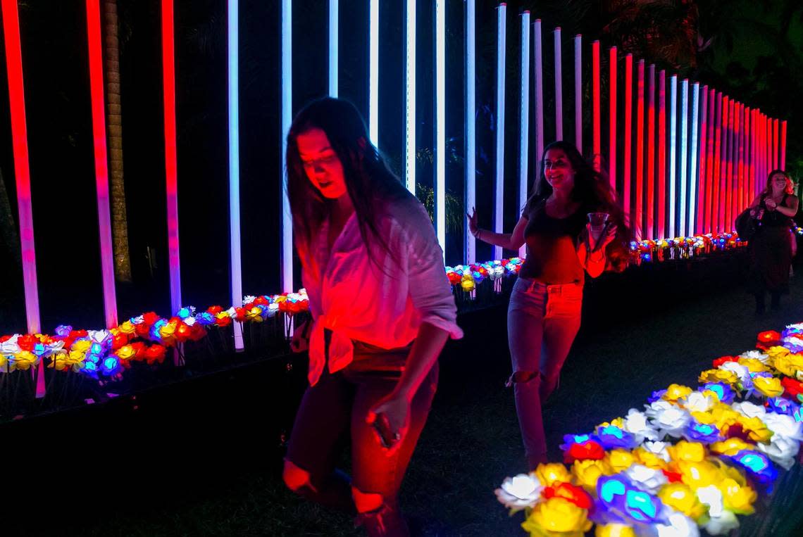 Guests run through a path of illuminated flowers while activating musical notes at NightGarden at Fairchild Tropical Garden.