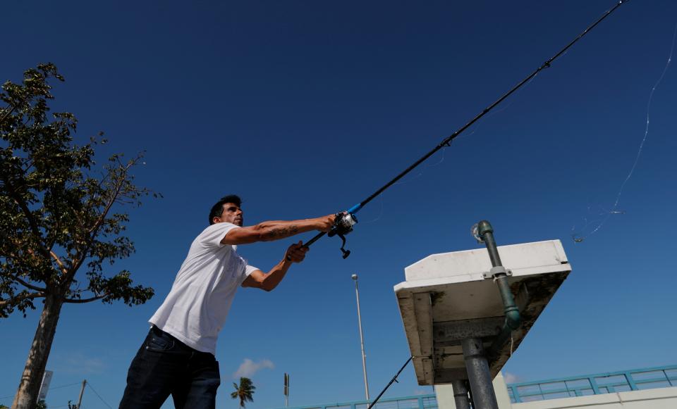 A Cape Coral man casts his fishing line from the Matlacha Bridge.