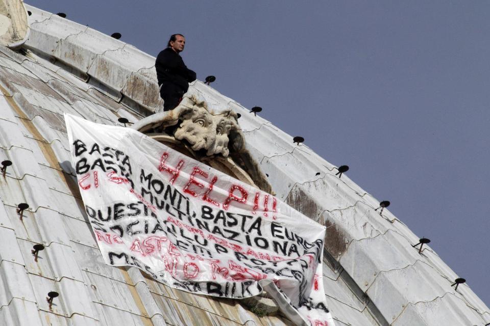 Italian businessman Marcello di Finizio stands above his banner which reads in Italian "Help!! Enough Monti (Italian Premier Mario Monti), enough Europe, enough multinationals, you are killing all of us. Development?? This is a social butchery!!", as he protests on St. Peter's 130-meter-high (42-feet-high) dome, at the Vatican, Wednesday, Oct. 3, 2012. An Italian man has eluded Vatican security and scaled the 130-meter-high (42-feet-high) dome of St. Peter's Basilica to protest Italian government and European Union policies. Officials said Wednesday that the man, who identified himself as the owner of a beach resort, refused appeals from government ministers offering to meet with him if he would come down. (AP Photo/Andrew Medichini)