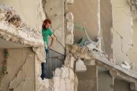 A man inspects a damaged site after what activists said was an airstrike by forces loyal to Syria's President Bashar al-Assad in Aleppo's rebel-controlled Al-Mashad neighborhood, September 17, 2015. REUTERS/Abdalrhman Ismail