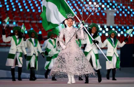 Feb 9, 2018; Pyeongchang, South Korea; A performer as Ngozi Onwumere of Nigeria carries the national flag during the Pyeongchang 2018 Olympic Winter Games Opening Ceremony at Pyeongchang Olympic Stadium. Mandatory Credit: Rob Schumacher-USA TODAY Sports