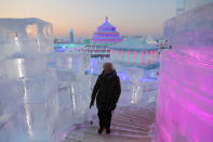 <p>A woman visits the ice sculptures illuminated by colored lights at the 34th Harbin International Ice and Snow Festival on Jan. 4. (Photo: Wu Hong/EPA-EFE/REX/Shutterstock) </p>