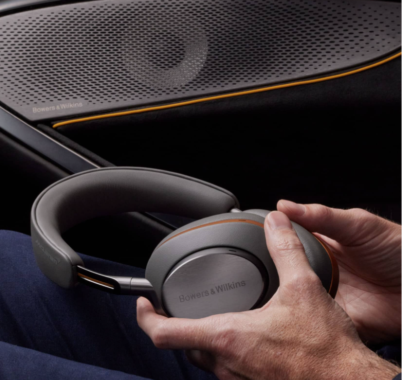 man's hands holding headphones in a car