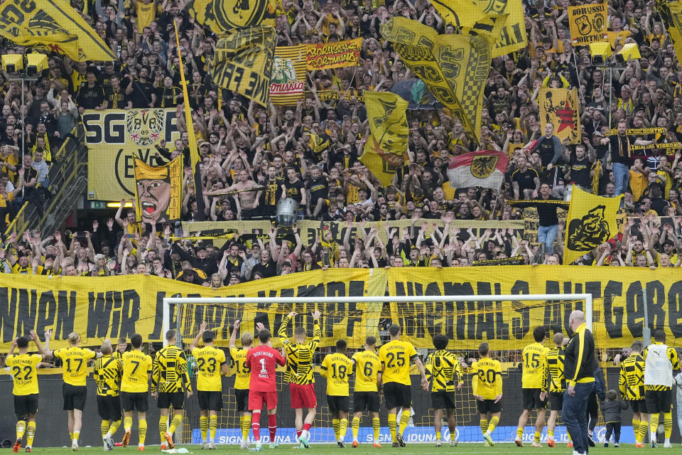 Dortmund players celebrate their victory after the German Bundesliga soccer match between Borussia Dortmund and VfL Wolfsburg in Dortmund, Germany, Saturday, May 7, 2023. (AP Photo/Martin Meissner)