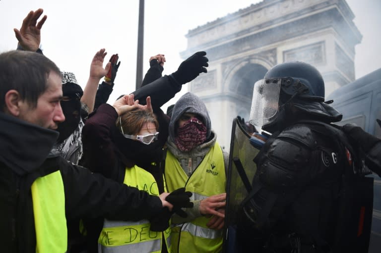 Riot police face demonstrators during a "Yellow vest" protest in Paris on December 1