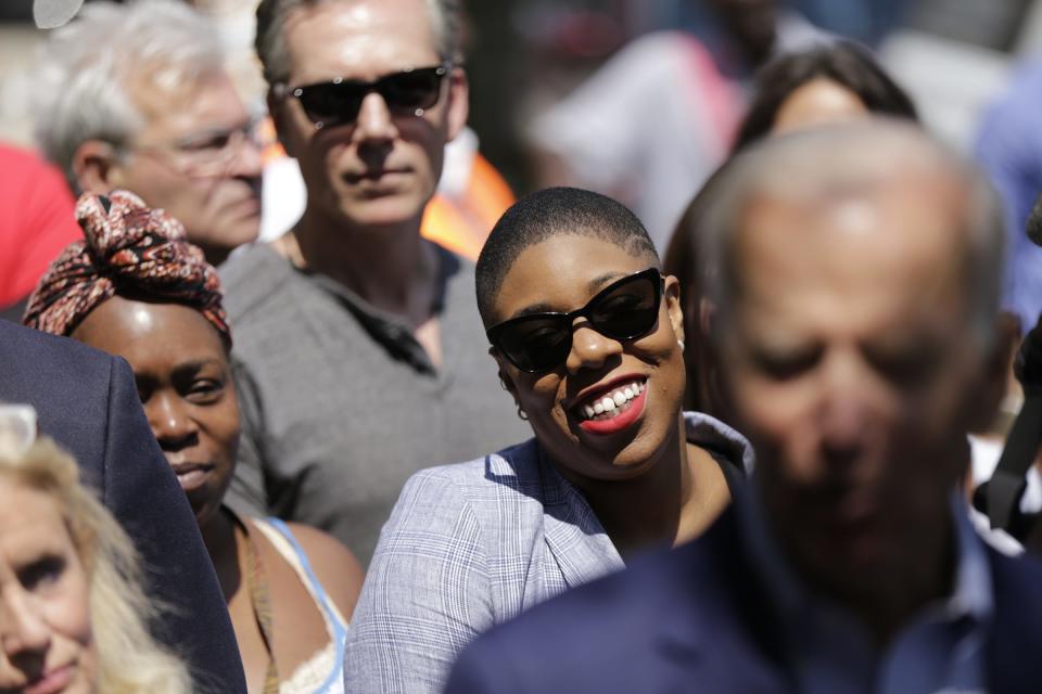 Symone Sanders, senior advisor to 2020 Democratic Presidential Candidate Joe Biden, listens to him speak to the press outside of Detroit One Coney Island in Detroit where he made a campaign stop on Thursday, Aug. 1, 2019. 