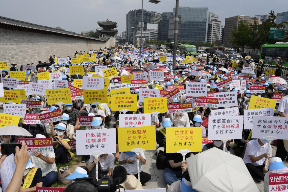 Unification Church followers hold signs during a rally in downtown Seoul, South Korea, Thursday, Aug. 18, 2022, protesting negative Japanese media coverage of their religion after the suspect in the assassination of former Japanese Prime Minster Shinzo Abe blamed the church for his family’s troubles. (AP Photo/Lee Jin-man)