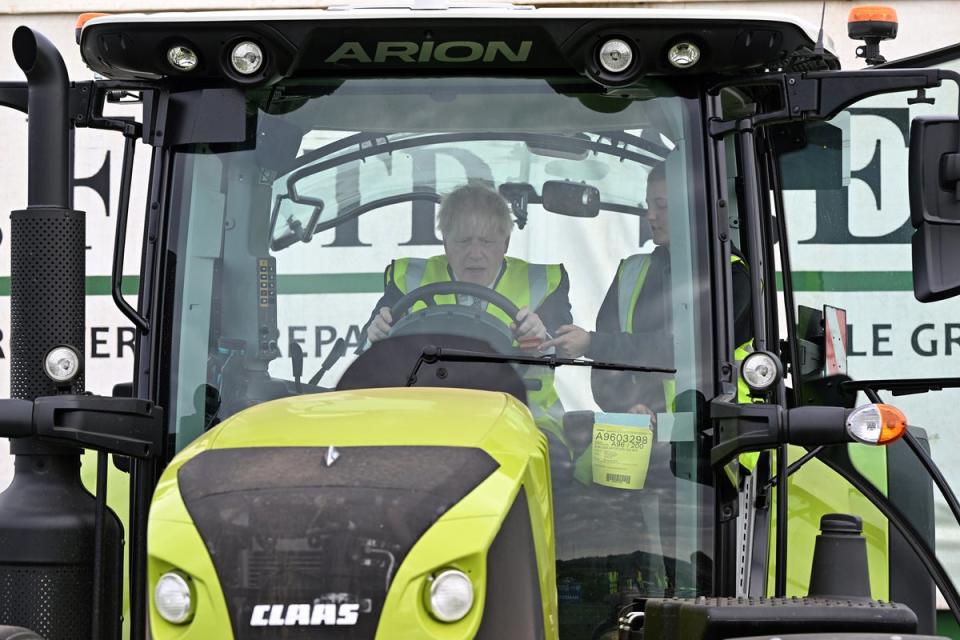 Prime Minister Boris Johnson is instructed as he drives a tractor during a visit to Southern England Farms Ltd in Hayle, Cornwall, ahead of the publication of the UK government’s food strategy white paper, Cornwall. Picture date: Monday June 13, 2022 (Justin Tallis/PA) (PA Wire)