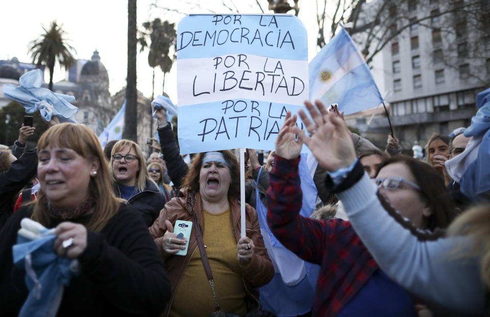 A woman holds a sign reading in Spanish "For democracy, for liberty, for country" during march in support of President Mauricio Macri, in Buenos Aires, Argentina, Saturday, Aug. 24, 2019. Following a social media campaign large numbers of people gathered in the center of Buenos Aires to show their support for Macri's administration. (AP Photo/Natacha Pisarenko)