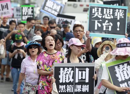 Activists march on the street during a protest in front of the Ministry of Education in Taipei, Taiwan, August 2, 2015. The placards read: " (Taiwan's Education Minister) Wu Se-hwa step down" and "Cancel the black box curriculum". REUTERS/Pichi Chuang