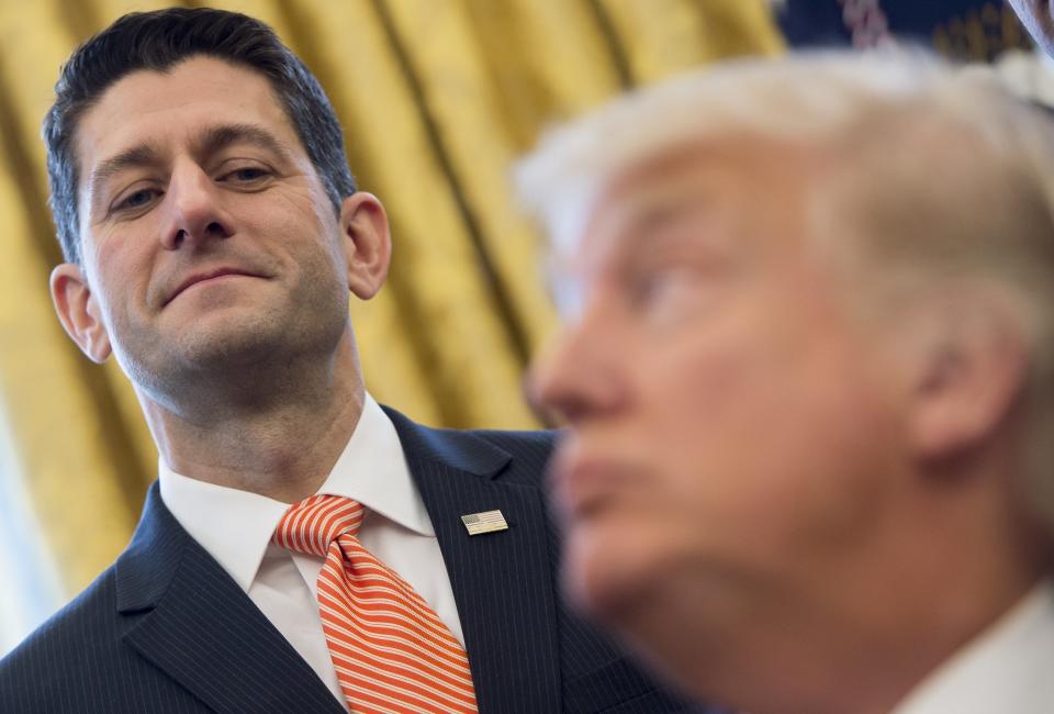 President Donald Trump speaks to Speaker of the House Paul Ryan after signing House Joint Resolution 41, which removes some Dodd-Frank regulations on oil and gas companies, during a bill signing ceremony in the Oval Office of the White House in Washington, DC, February 14, 2017.