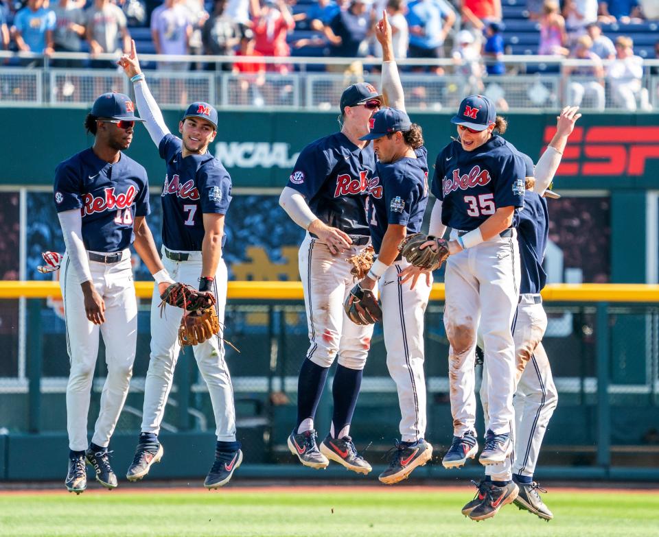 Ole Miss players TJ McCants (16), Jacob Gonzalez (7), Tim Elko (25), Peyton Chatagnier (1) and Kevin Graham (35) celebrate after defeating  Arkansas on Thursday to advance to thr College World Series Finals.