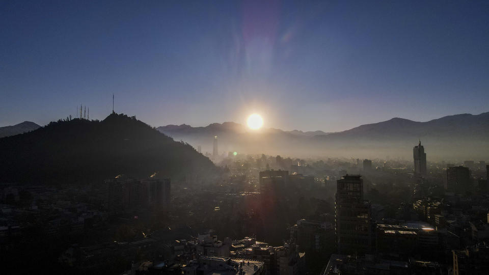 El sol sale por entre las nevadas montañas de los Andes, en Santiago, Chile, el 8 de mayo de 2024. (AP Foto/Esteban Félix)