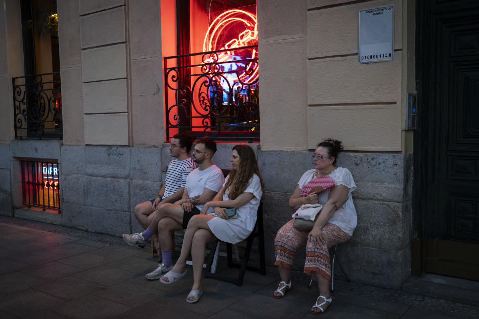 Un grupo de personas sigue una representación de "Turandot", de Giacomo Puccini, en una pantalla gigante instalada el exterior del Teatro Real de Madrid, el 14 de julio de 2023. Desde hace ocho años, el Teatro Real ofrece la retransmisión gratuita de las óperas que se representan en su escenario a pueblos y ciudades de toda España. El objetivo es incentivar el interés por la ópera y librarla de su etiqueta de elitista. (AP Foto/Bernat Armangué)