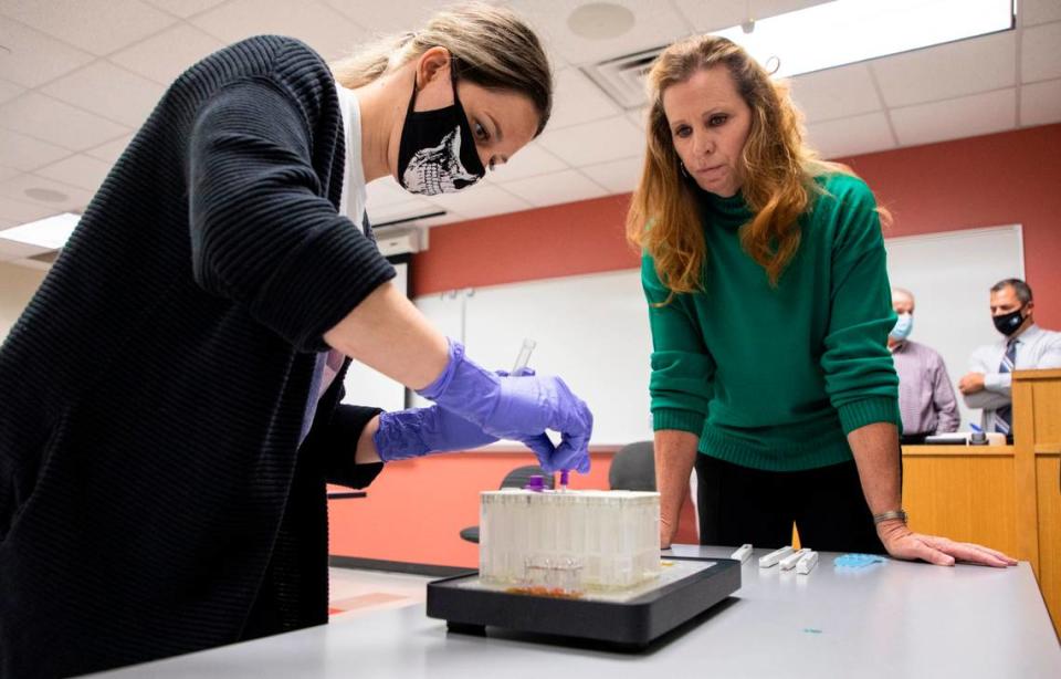 Wake Tech Community College student Claire Broucek, left, places a DNA sample into an ANDE Rapid DNA machine cartridge with professor Janie Slaughter, right, in an Investigative Principles course at the school’s Public Safety Education Campus in Raleigh, N.C. on Tuesday, Nov. 2, 2021.