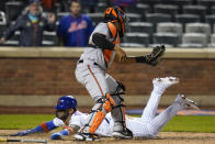 New York Mets' Jonathan Villar slides past Baltimore Orioles catcher Pedro Severino to score the game-winning run during in a baseball game Tuesday, May 11, 2021, in New York. The Mets won 3-2. (AP Photo/Frank Franklin II)