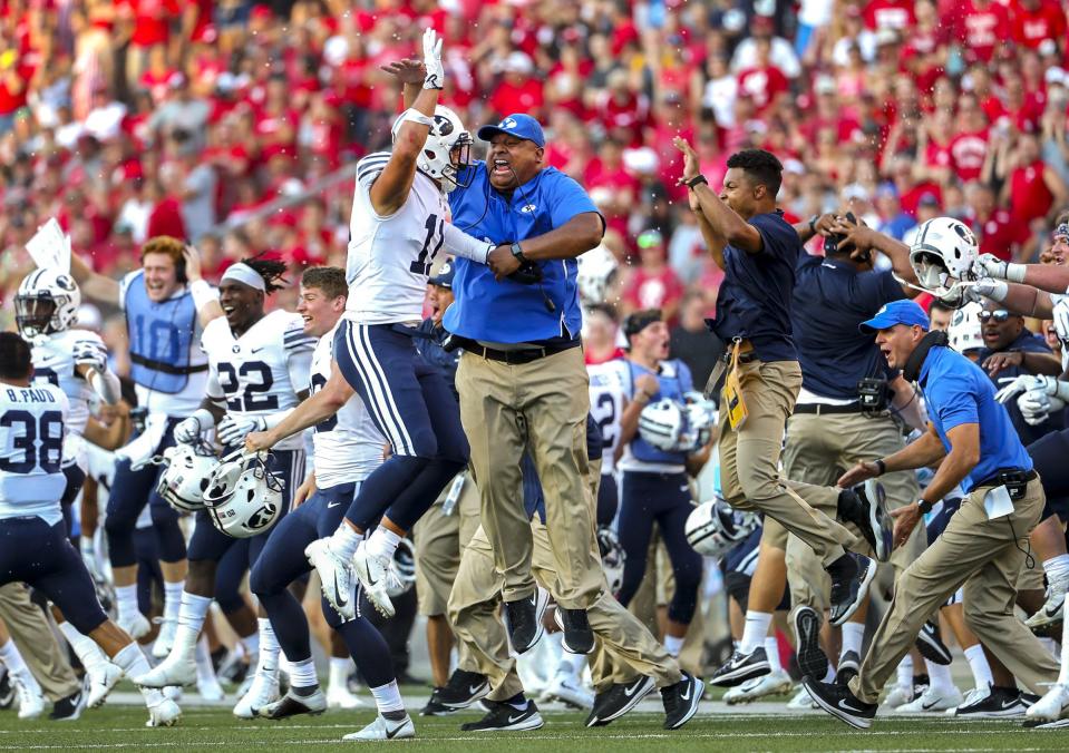 BYU head coach Kalani Sitake leaps into the air as he celebrates with BYU defensive back Austin Lee after a Wisconsin field goal sailed wide, giving the Cougars the victory at Camp Randall Stadium in Madison, Wis., on Saturday, Sept. 15, 2018. | Steve Griffin, Deseret News