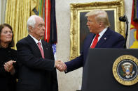 President Donald Trump greets auto racing great Roger Penske during a Presidential Medal of Freedom ceremony in the Oval Office of the White House, Thursday, Oct. 24, 2019, in Washington, as Kathy Penske looks on. (AP Photo/Alex Brandon)