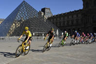 Jonas Vingegaard (de amarillo) pasa frente al Museo de Louvre durante la 21ra etapa del Tour de Francia, el domingo 24 de julio de 2022. (AP Foto/Bertrand Guay/Pool vía AP)