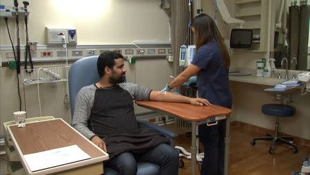 Manni Baez (L), 30, prepares to receive an antibody infusion of a drug that is part of a clinical trial for a functional HIV cure at the National Institutes of Health in Bethesda, Maryland, U.S. November 22, 2016 in this still image from video. REUTERS/Gershon Peaks/RVN