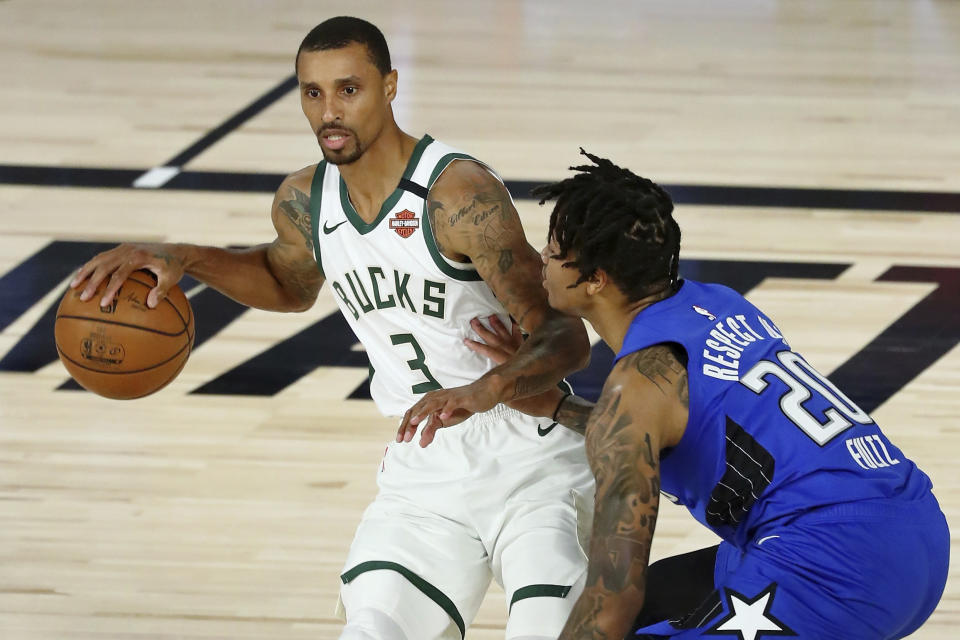 Milwaukee Bucks guard George Hill (3) dribbles while defended by Orlando Magic guard Markelle Fultz (20) during the first half of Game 1 of an NBA basketball first-round playoff series, Tuesday, Aug. 18, 2020, in Lake Buena Vista, Fla. (Kim Klement/Pool Photo via AP)