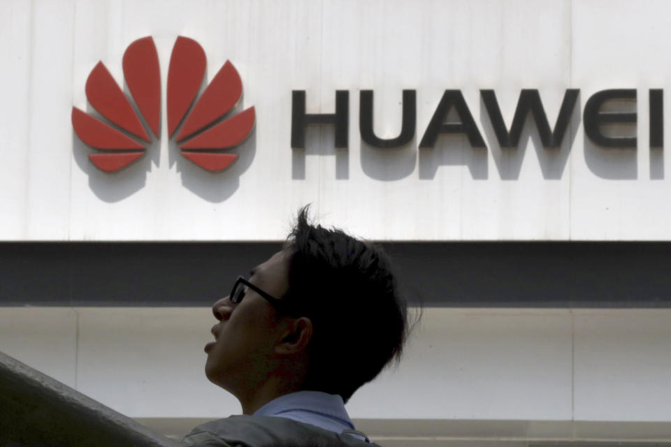 In this photo taken Thursday, May 16, 2019, a man past by a Huawei store in Beijing. Google is assuring users of Huawei smartphones the American company's services still will work on them following U.S. government restrictions on doing business with the Chinese tech giant. (AP Photo/Ng Han Guan)