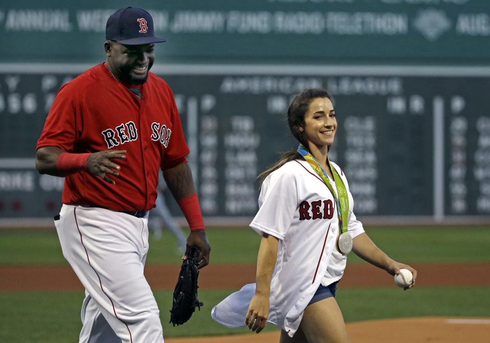 2016: Aly Raisman, U.S. Olympic gold medalist in gymnastics, walks with Boston Red Sox's David Ortiz after throwing a ceremonial first pitch before a baseball game between the Boston Red Sox and the Kansas City Royals at Fenway Park.