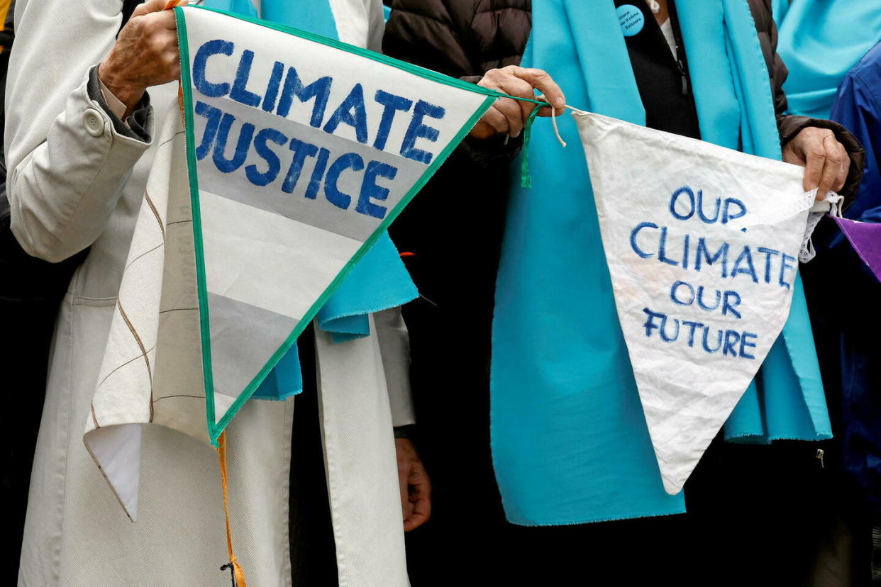 Des membres et des soutiens de l'association des Aînées pour la protection du climat brandissent pancartes et slogans devant la Cour européenne des droits de l'homme.  - Credit:Christian Hartmann / REUTERS