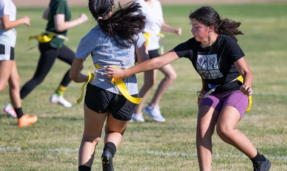 Jovanna Herrera, right, pulls the flag on Andrea Fuentes during Escalon girls flag football practice at Escalon High School in Escalon, Calif., Thursday, August 3, 2023.