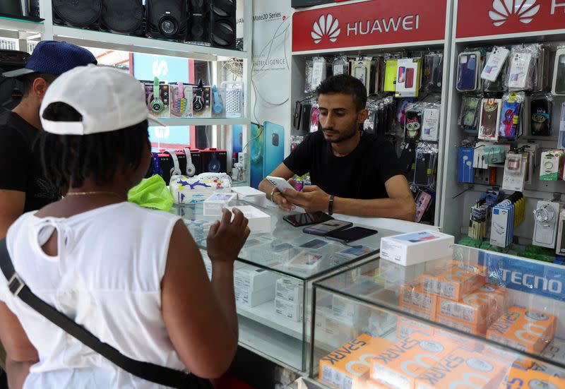 A vendor assists customers inside a mobile shop in Dora