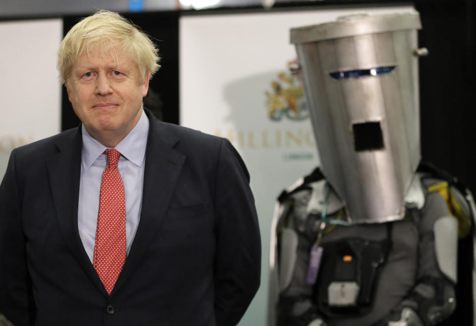 Independent candidate Count Binface stands with Britain's Prime Minister and Conservative Party leader Boris Johnson as they wait for the Uxbridge and South Ruislip constituency count declaration at Brunel University in Uxbridge, London, Friday, Dec. 13, 2019. (AP Photo/Kirsty Wigglesworth)