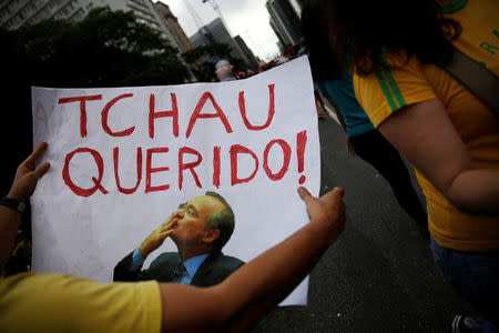 A man holds a sign that reads "Bye Darling" in reference to Brazil's Senate President Renan Calheiros, as he takes part in a protest against corruption at Paulista Avenue in Sao Paulo, Brazil, December 4, 2016. REUTERS/Nacho Doce