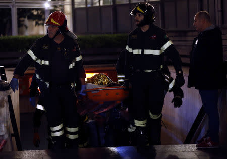 Fire fighters carry an injured person outside the underground where some of CSKA Moscow supporters were injured in Rome, Italy, October 23, 2018. REUTERS/Yara Nardi