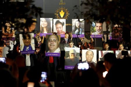 Posters of the 14 people killed are displayed on stage during a vigil for San Bernardino County employees after last week's shooting in San Bernardino, California December 7, 2015. REUTERS/Patrick T. Fallon