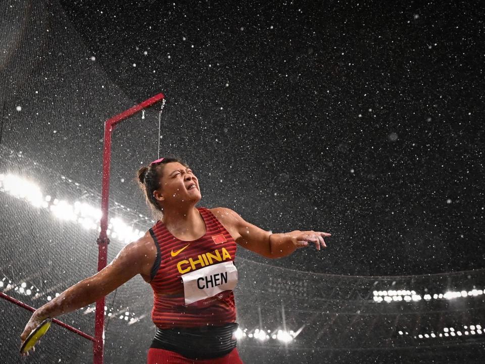 China's Chen Yang throws a discus in the rain at the Tokyo Olympics.